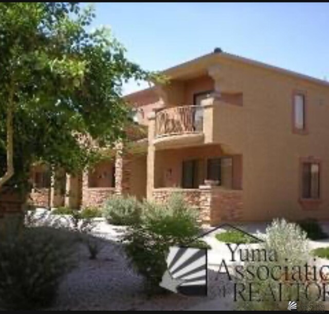 3567 W 22nd Pl, Yuma, AZ 85364 - rear view of house with a balcony and stucco siding