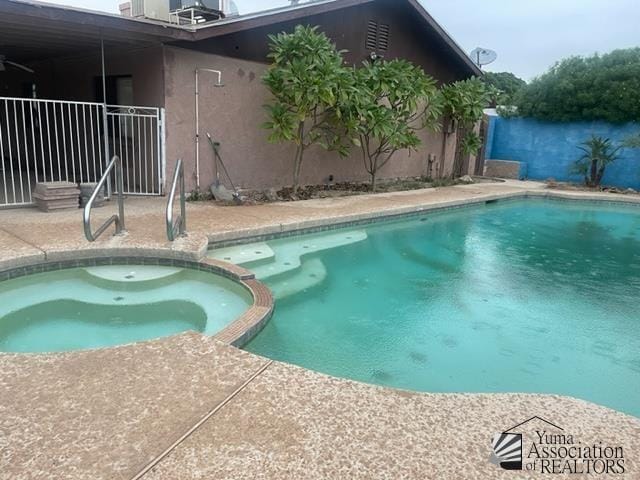 1671 W Del Oro Ln, Yuma, AZ 85364 - view of swimming pool featuring a pool with connected hot tub, a patio area, and fence