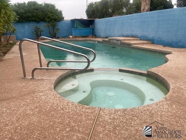 1671 W Del Oro Ln, Yuma, AZ 85364 - view of swimming pool featuring a pool with connected hot tub and a fenced backyard