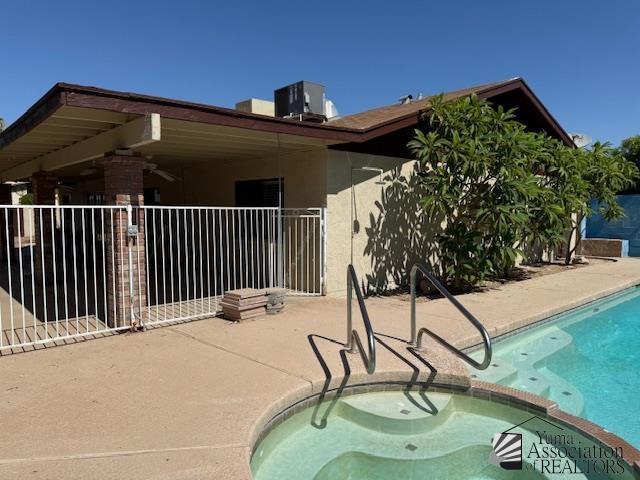 1671 W Del Oro Ln, Yuma, AZ 85364 - rear view of property with a patio, stucco siding, and a pool with connected hot tub