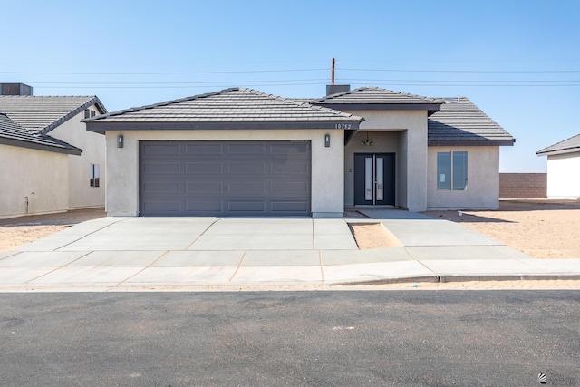 10752 E 45th Pl, Yuma, AZ 85367 - prairie-style home featuring concrete driveway, an attached garage, stucco siding, french doors, and a tiled roof