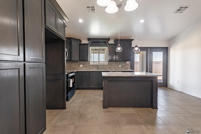 10752 E 45th Pl, Yuma, AZ 85367 - kitchen with black range with electric stovetop, decorative backsplash, a kitchen island, light tile patterned floors, and recessed lighting