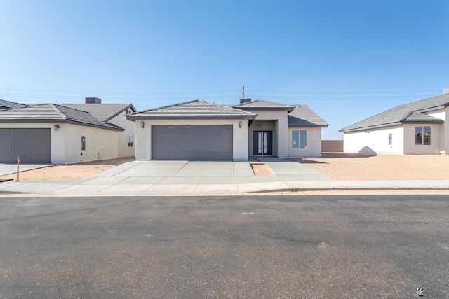 10752 E 45th Pl, Yuma, AZ 85367 - view of front facade with a garage, stucco siding, driveway, and a tiled roof