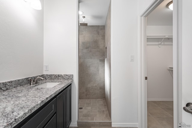 10752 E 45th Pl, Yuma, AZ 85367 - bathroom featuring a tile shower, a spacious closet, vanity, and tile patterned floors