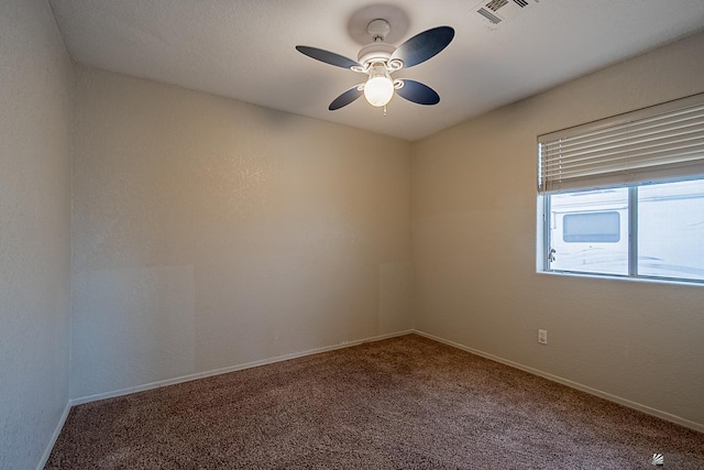 carpeted spare room featuring ceiling fan, visible vents, and baseboards