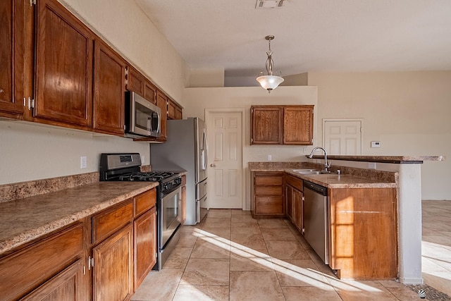 kitchen with pendant lighting, a peninsula, brown cabinets, a sink, and appliances with stainless steel finishes
