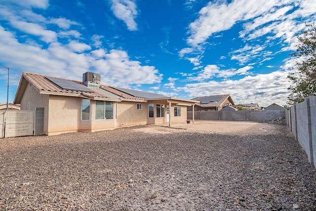 back of property with stucco siding, a fenced backyard, solar panels, a patio, and a tiled roof