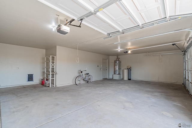 garage with strapped water heater and a garage door opener