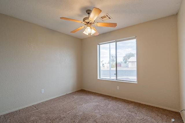 empty room with visible vents, baseboards, ceiling fan, and light colored carpet