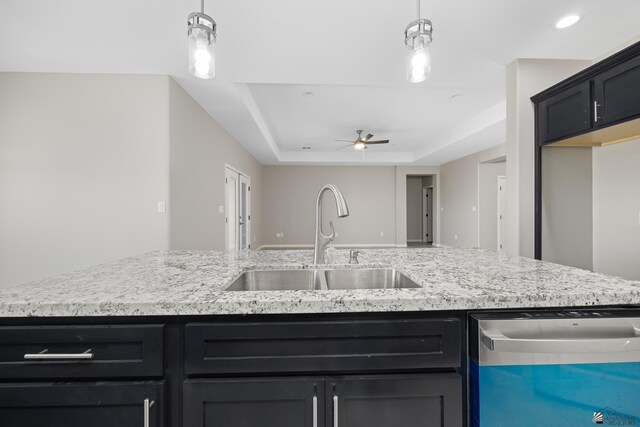 3562 S Sage Ave, Yuma, AZ 85365 - kitchen with dishwashing machine, ceiling fan, dark cabinetry, light stone counters, and a raised ceiling