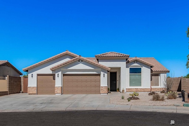 11608 E 26th Ln, Yuma, AZ 85367 - view of front of house with an attached garage, a tiled roof, stucco siding, and stone siding