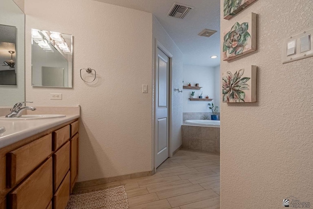 11608 E 26th Ln, Yuma, AZ 85367 - bathroom featuring a bath, double vanity, and a textured wall