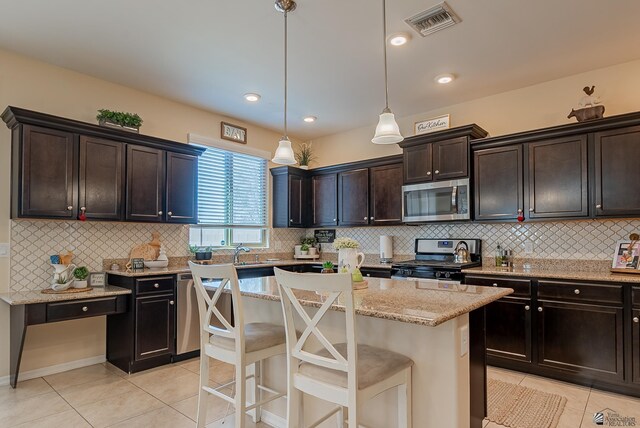 6533 E 35th Pl, Yuma, AZ 85365 - kitchen featuring stainless steel appliances, light tile patterned flooring, light stone countertops, and backsplash