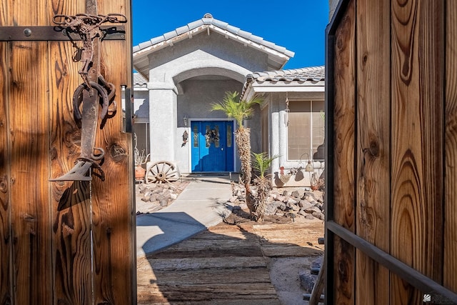 entrance to property with stucco siding and a tile roof
