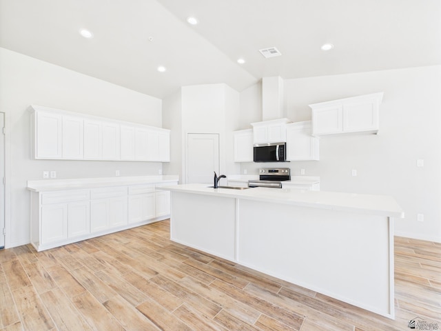 12116 E Calle Del Cid Unit B, Yuma, AZ 85367 - kitchen with stainless steel appliances, a center island with sink, light countertops, and high vaulted ceiling