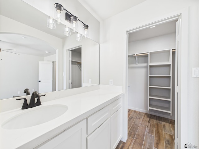 12116 E Calle Del Cid Unit B, Yuma, AZ 85367 - bathroom featuring a walk in closet, vanity, wood finished floors, and a ceiling fan