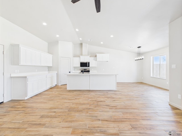 12116 E Calle Del Cid Unit B, Yuma, AZ 85367 - kitchen with appliances with stainless steel finishes, ceiling fan, light wood finished floors, a kitchen island with sink, and open floor plan