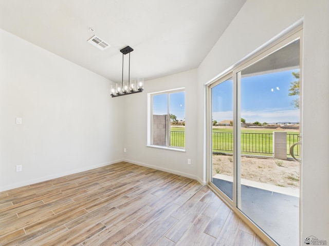 12116 E Calle Del Cid Unit B, Yuma, AZ 85367 - empty room with light wood-style flooring and a chandelier