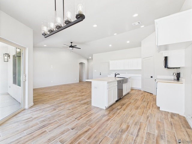 12116 E Calle Del Cid Unit B, Yuma, AZ 85367 - kitchen with appliances with stainless steel finishes, vaulted ceiling, open floor plan, arched walkways, and white cabinets