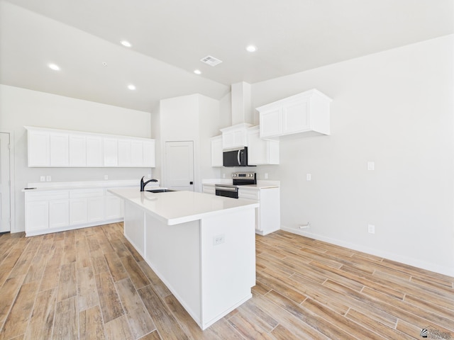 12116 E Calle Del Cid Unit B, Yuma, AZ 85367 - kitchen featuring stainless steel appliances, light wood-type flooring, a center island with sink, light countertops, and white cabinetry