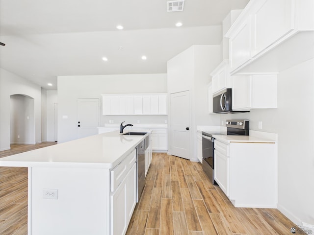 12116 E Calle Del Cid Unit B, Yuma, AZ 85367 - kitchen featuring stainless steel appliances, light wood-type flooring, arched walkways, light countertops, and recessed lighting