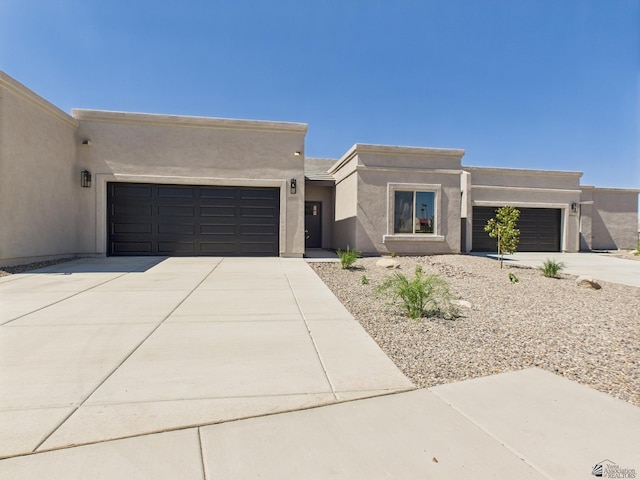 12116 E Calle Del Cid Unit B, Yuma, AZ 85367 - pueblo-style house featuring an attached garage, concrete driveway, and stucco siding