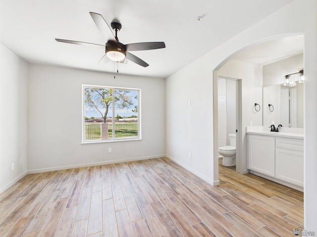 12116 E Calle Del Cid Unit B, Yuma, AZ 85367 - empty room with arched walkways, light wood-style floors, and a ceiling fan