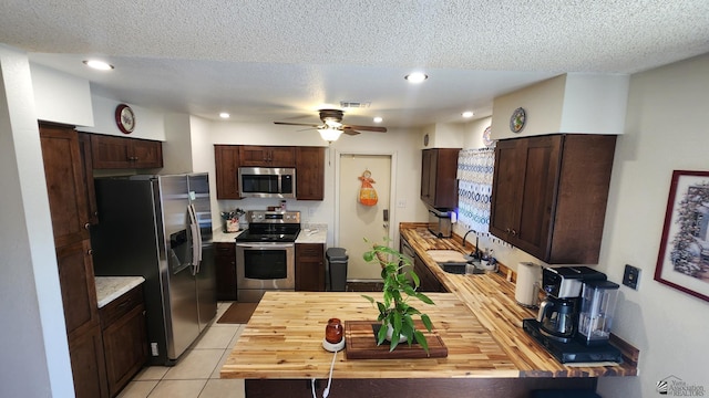 4671 W 21st Ln, Yuma, AZ 85364 - kitchen featuring stainless steel appliances, ceiling fan, light countertops, dark brown cabinetry, and a textured ceiling