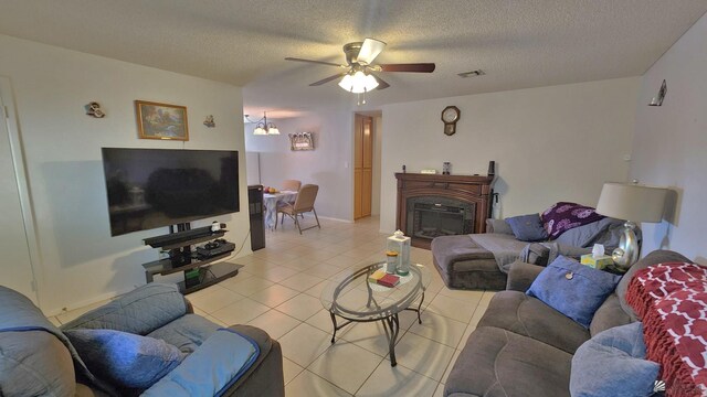 4671 W 21st Ln, Yuma, AZ 85364 - living room featuring ceiling fan, light tile patterned flooring, a textured ceiling, and a glass covered fireplace