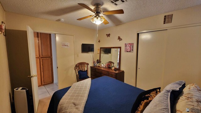 4671 W 21st Ln, Yuma, AZ 85364 - bedroom featuring a textured ceiling, light tile patterned floors, a closet, and a ceiling fan