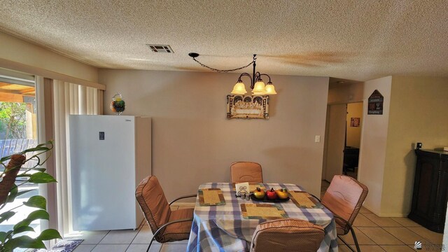 4671 W 21st Ln, Yuma, AZ 85364 - dining room with light tile patterned flooring, a chandelier, and a textured ceiling