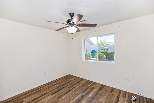 spare room featuring baseboards, a ceiling fan, wood finished floors, and visible vents