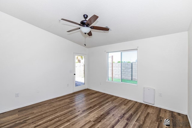 spare room with visible vents, lofted ceiling, wood finished floors, baseboards, and ceiling fan