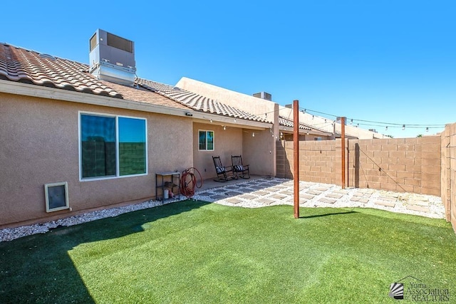 back of property featuring central air condition unit, a patio area, fence, and a yard