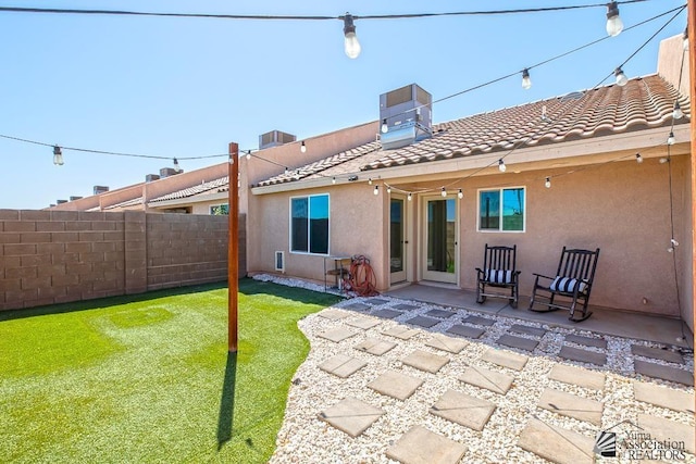 rear view of house with fence, stucco siding, a patio area, central air condition unit, and a tiled roof