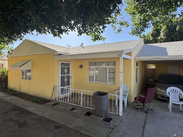 view of front facade with a carport and stucco siding