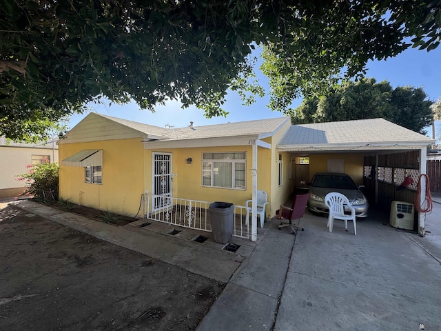 view of front of property featuring a carport, concrete driveway, and stucco siding