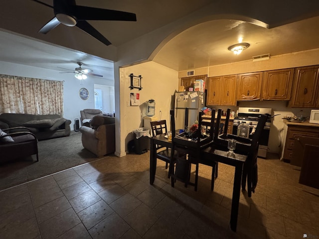 dining area featuring arched walkways, visible vents, and a ceiling fan