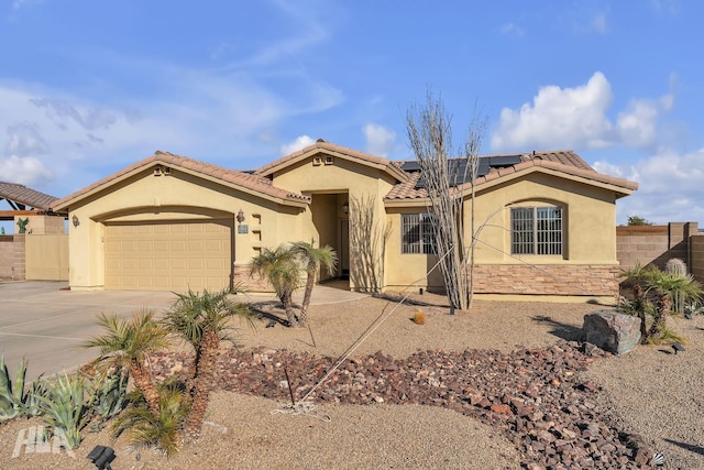 11812 E Eclipse Ct, Yuma, AZ 85367 - view of front facade featuring driveway, fence, roof mounted solar panels, an attached garage, and stucco siding