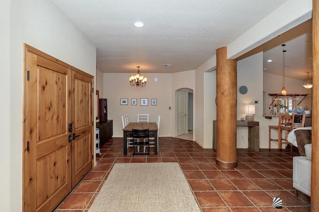 dining area with recessed lighting, a textured ceiling, dark tile patterned flooring, arched walkways, and a notable chandelier