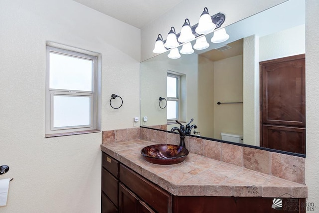 bathroom with visible vents, toilet, and vanity