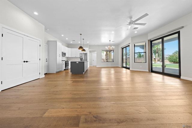 10369 S Fairway Loop, Yuma, AZ 85367 - unfurnished living room with light wood-style floors, recessed lighting, ceiling fan, and a chandelier