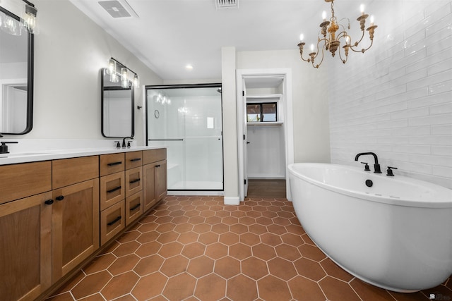 10369 S Fairway Loop, Yuma, AZ 85367 - bathroom with a stall shower, double vanity, a freestanding tub, tile patterned floors, and a chandelier