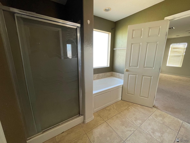 bathroom with shower with separate bathtub, tile patterned floors, and vaulted ceiling