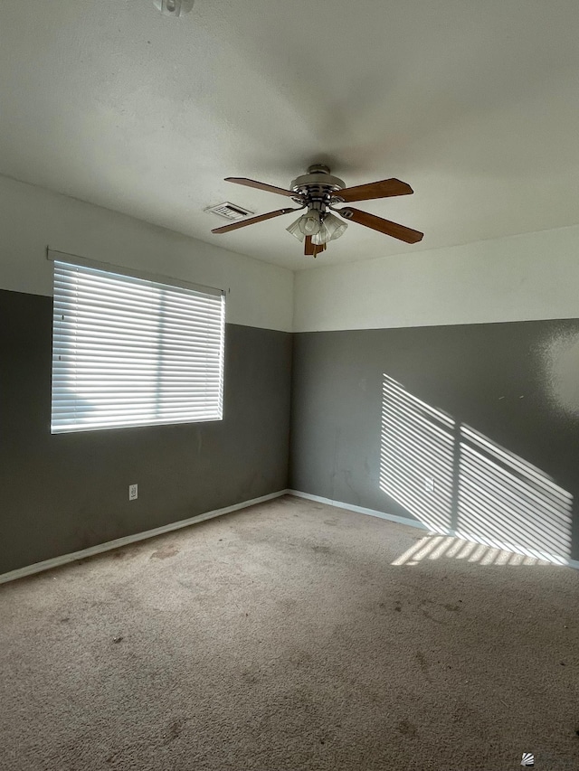 carpeted empty room featuring ceiling fan