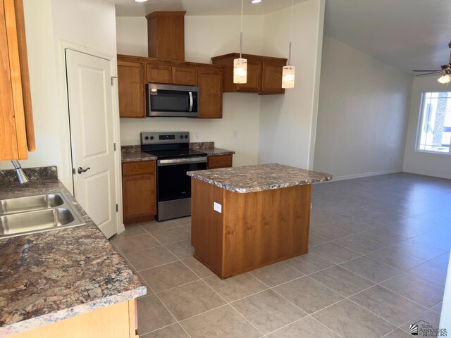 3751 E Santa Palmira St, San Luis, AZ 85336 - kitchen with light tile patterned flooring, a center island, brown cabinets, a sink, and appliances with stainless steel finishes