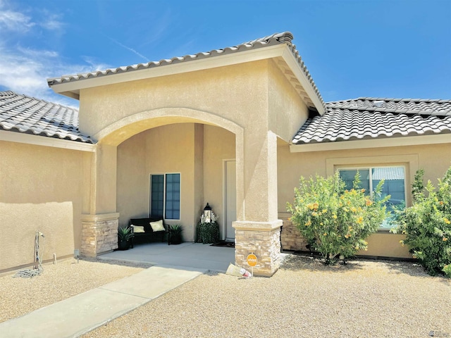 doorway to property featuring stucco siding and a tile roof