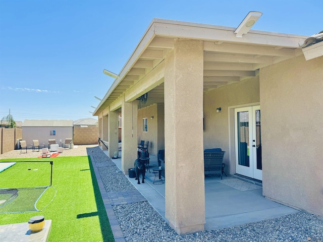 view of patio featuring an outdoor structure, french doors, a fenced backyard, and a shed