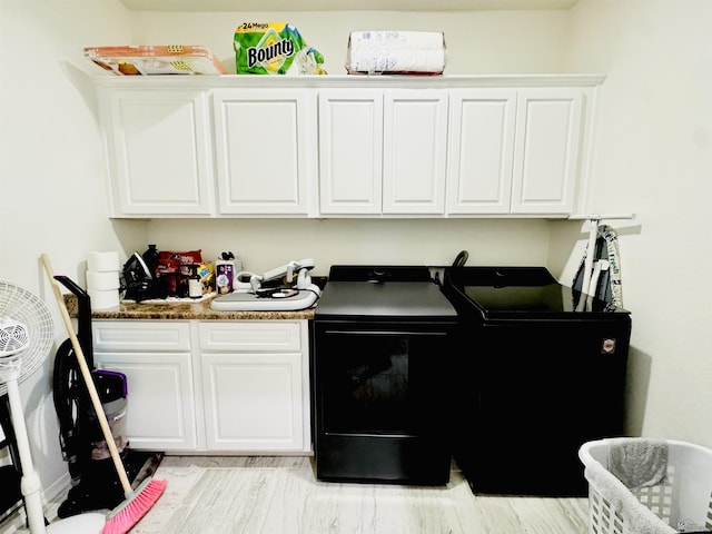 washroom featuring separate washer and dryer and cabinet space