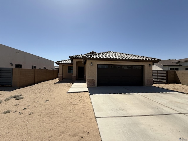 126 N Joe Harper Ct, San Luis, AZ 85349 - mediterranean / spanish home with concrete driveway, a garage, stucco siding, and a tile roof